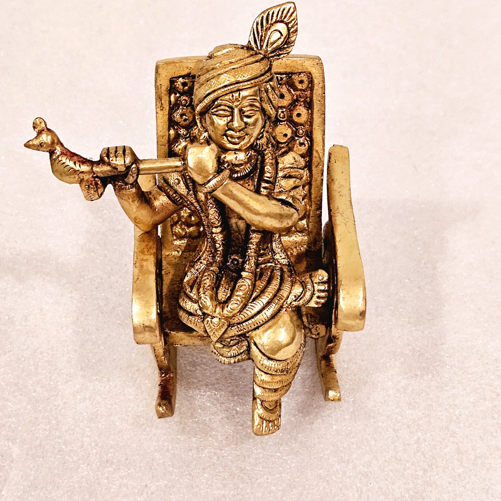Swinging Lord Shri Krishna on a rocking chair.