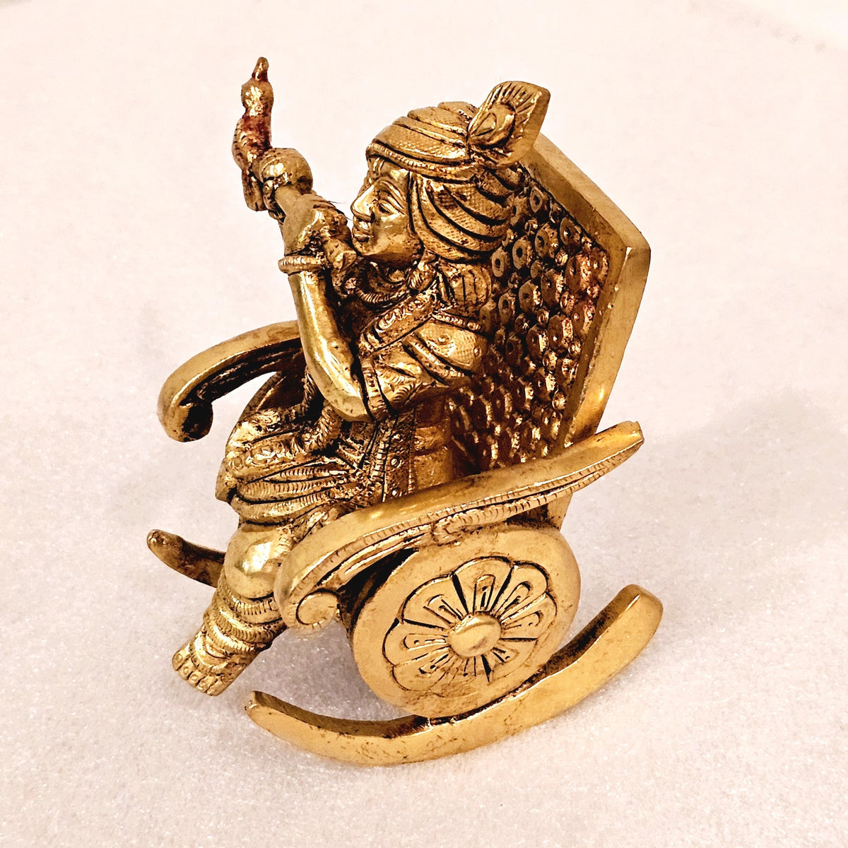 Swinging Lord Shri Krishna on a rocking chair.